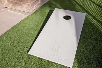 A white AMAVIDA sign is placed on a green artificial grass surface.